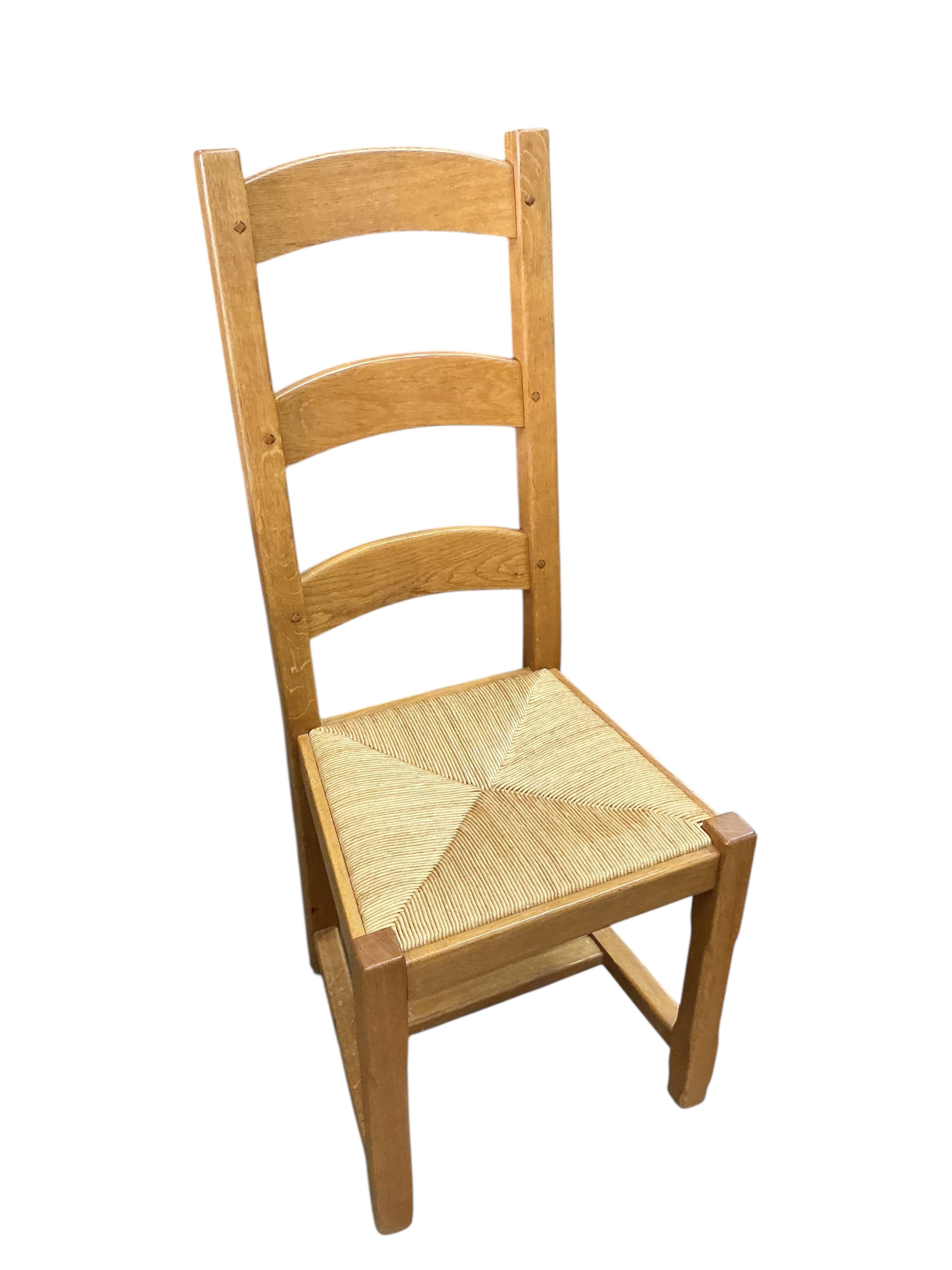 A set of eight contemporary oak rush seat ladderback dining chairs